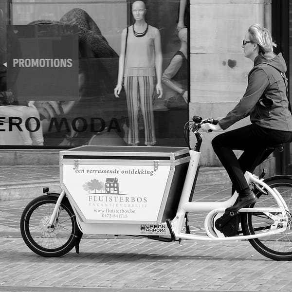 femme qui se déplace avec un vélo cargo de type biporteur