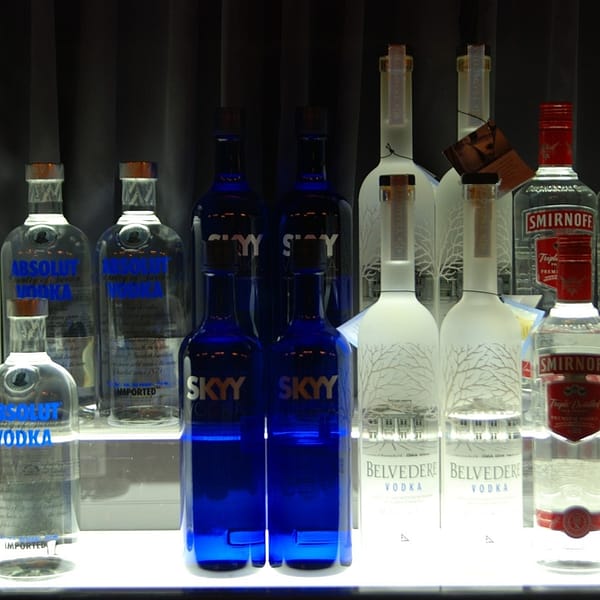 plusieurs bouteilles de différentes marques de vodka sur un comptoir de bar