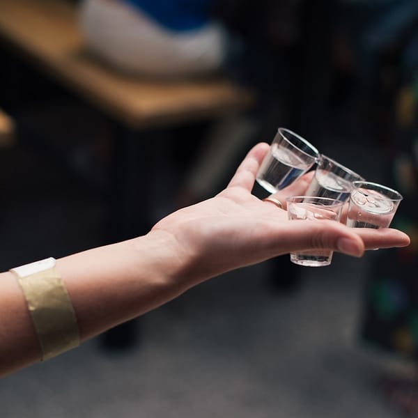 plusieurs shots de vodka dans une main