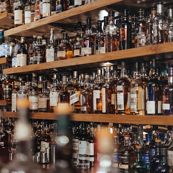 des rangées de bouteilles de whiskies dans un bar