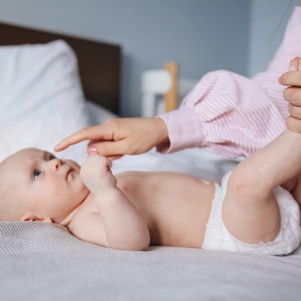 un parent qui change la couche de son bébé