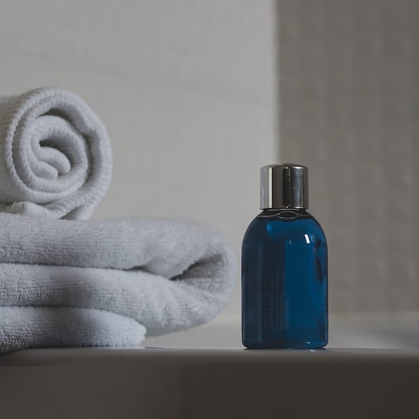 un gel douche à côté de serviettes dans une salle de bain