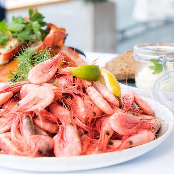plat rempli de crevettes entières avec du citron