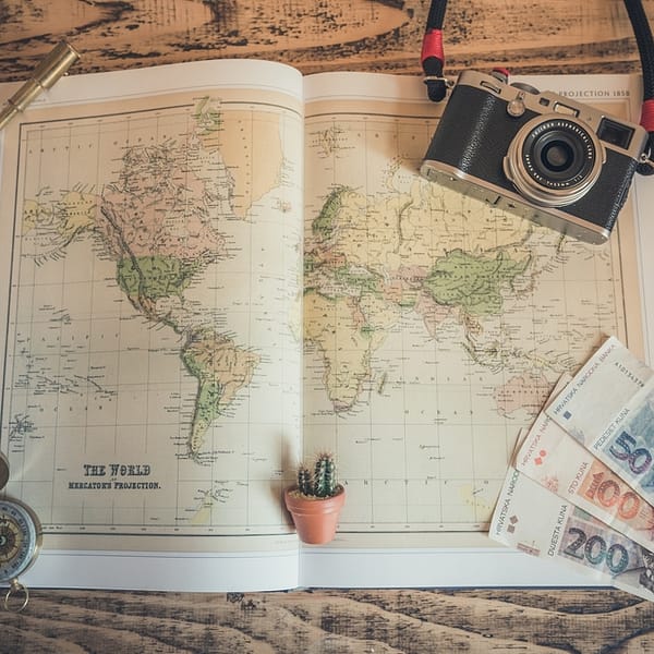 carte du monde, boussole et appareil photo qui symbolisent le voyage personnalisé