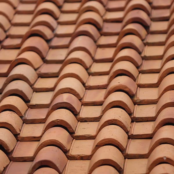 Des tuiles en terre cuites emboitées sur un toit en France