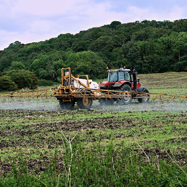 tracteur qui pulvérise un fertilisant dans un champ