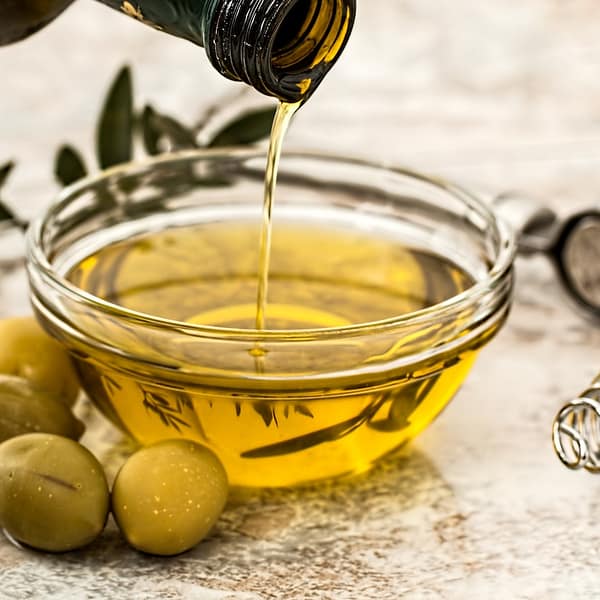 bouteille d'huile d'olive qui se verse dans un petit bol