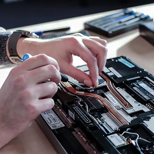 technicien qui répare un ordinateur portable