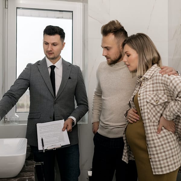 agent mandataire qui fait visiter la salle de bain à des clients