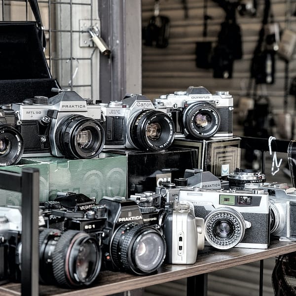 plusieurs appareils photo sur une étagère d'un magasin