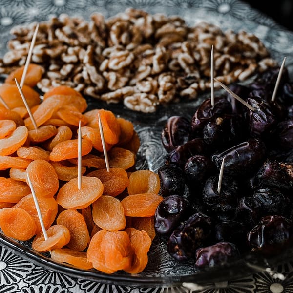 un plateau avec des abricots secs et des dattes séchées