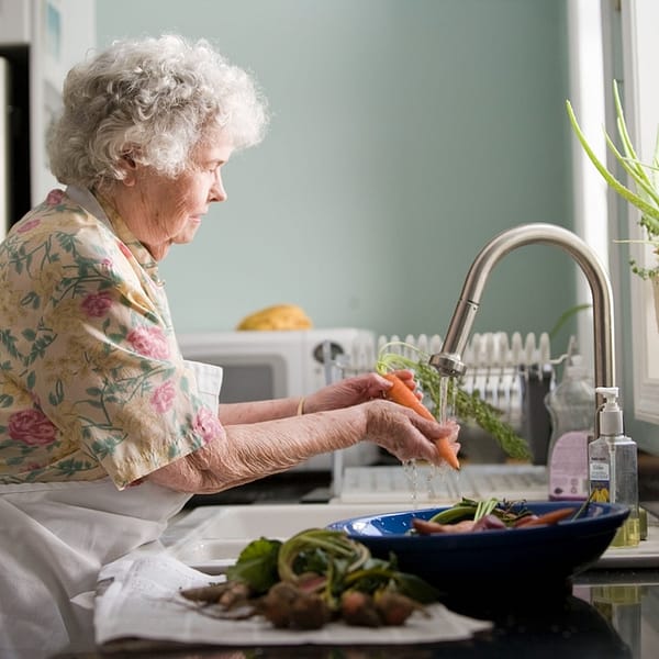 personne âgée qui fait la cuisine dans une résidence senior