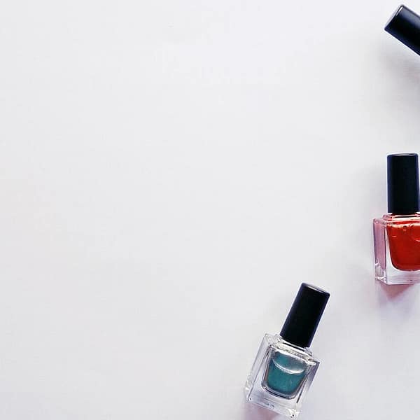 trois flacons de vernis à ongle sur fond blanc