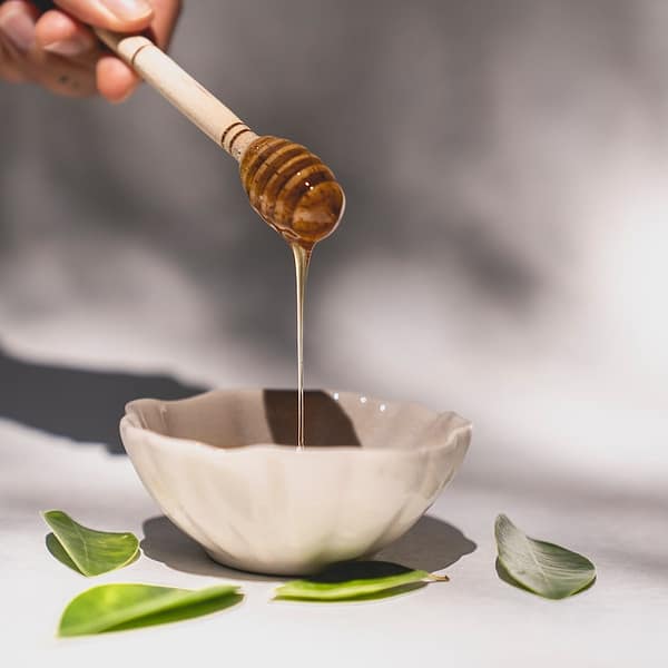 cuillère au miel au-dessus d'un bol
