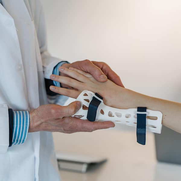 un médecin qui passe une prothèse au poignet d'un patient