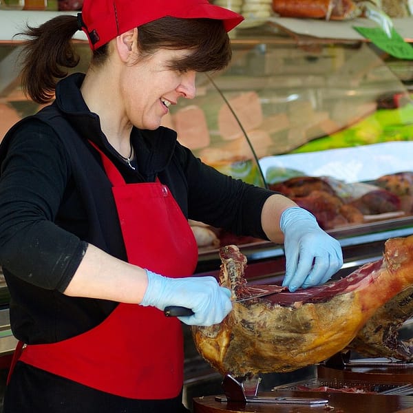 boucher qui coupe de la viande dans son atelier