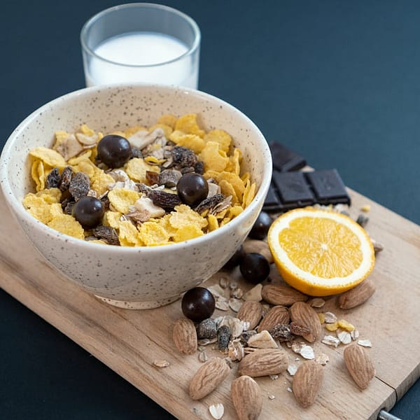 Bol rempli de céréales pour petit déjeuner avec un verre de lait