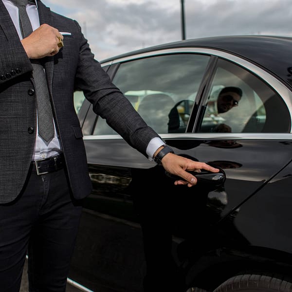 chauffeur qui ouvre la porte à un client
