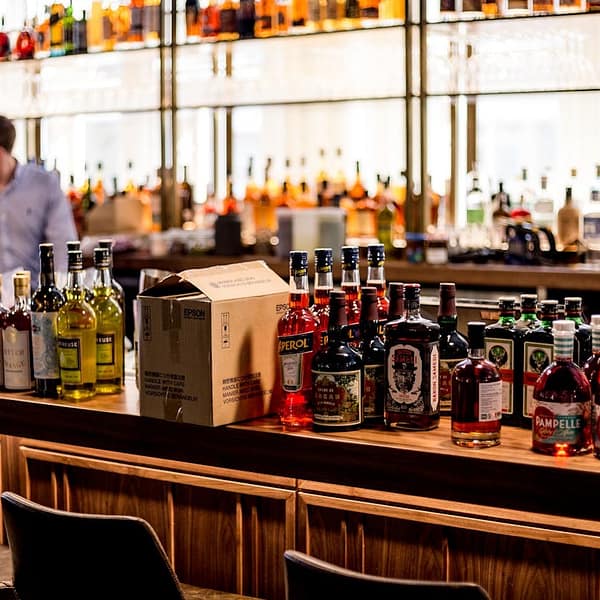 comptoir d'un bar avec plusieurs bouteilles de spiritueux
