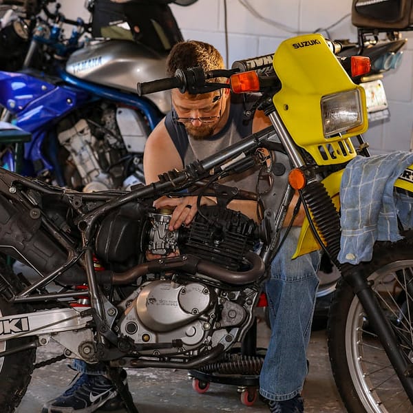 mécano qui répare une moto de sport