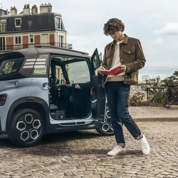 étudiant à Paris à côté de la Citroën Ami