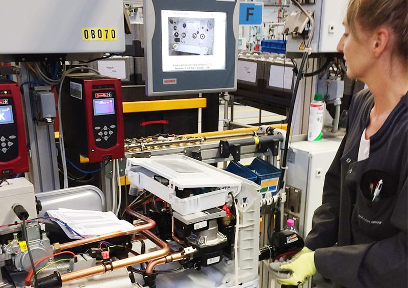 une salariée qui fabrique une pompe à chaleur dans une usine