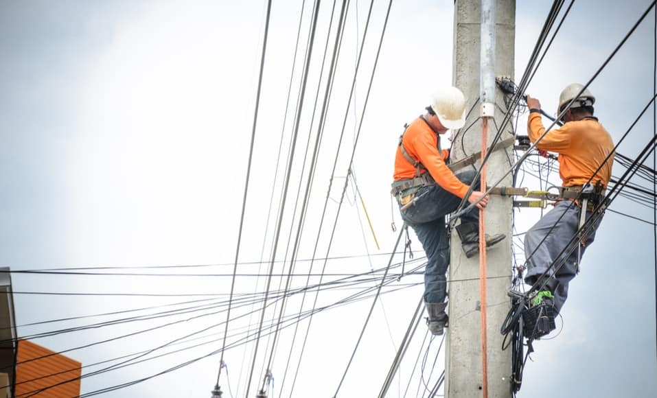 deux techniciens intervenant sur une ligne à haute tension